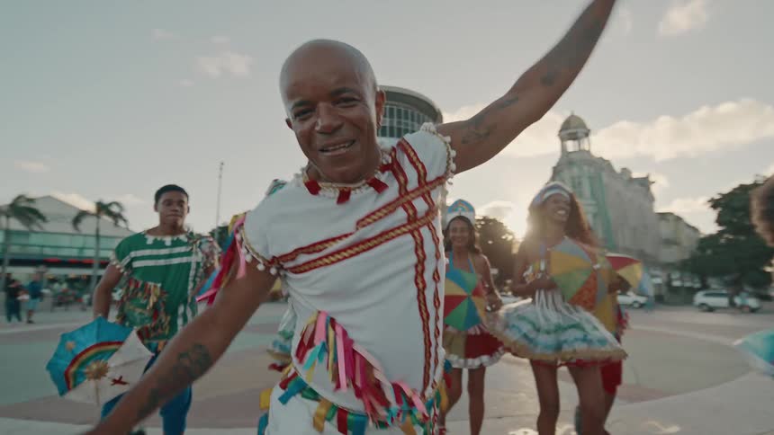 The dancers wave their arms around and smile