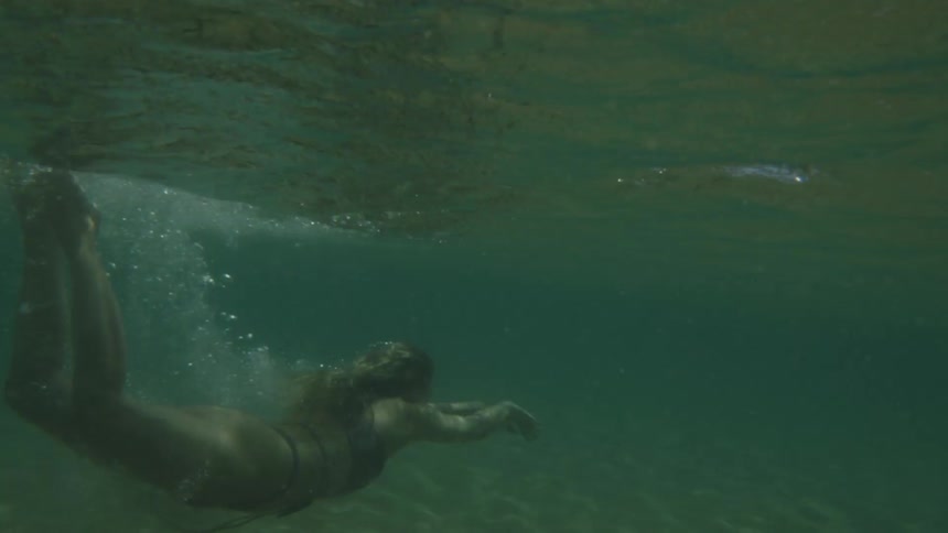 Woman in bikini swimming in a crystal clear and calm sea