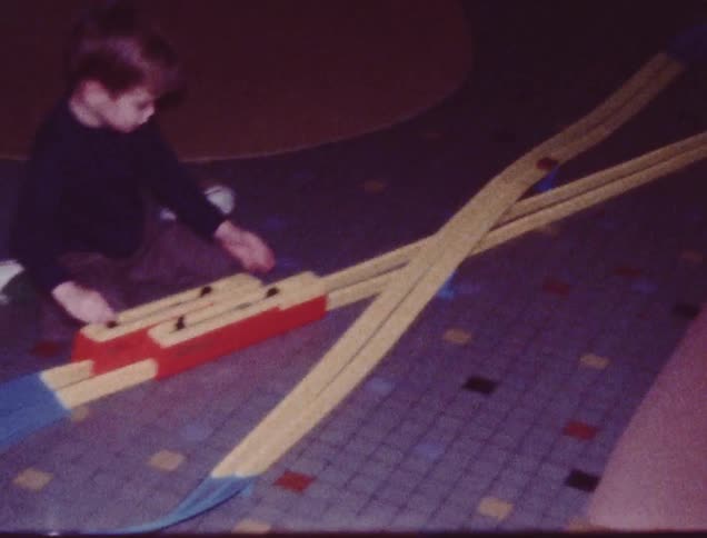 A boy is playing with a train set