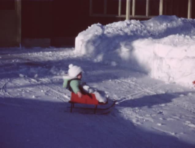 A young child is pulled on a sled
