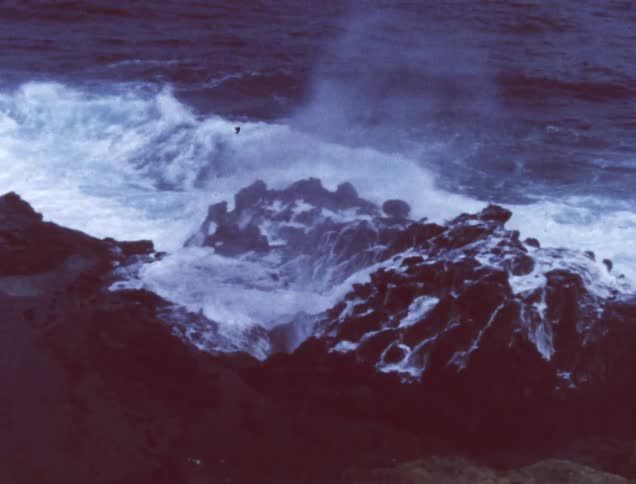 Ocean waves crashing into rocks and spewing out of rock crevices