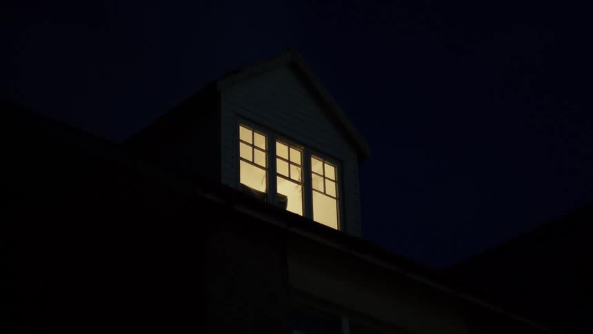 View of the outside of a house with lights on at night