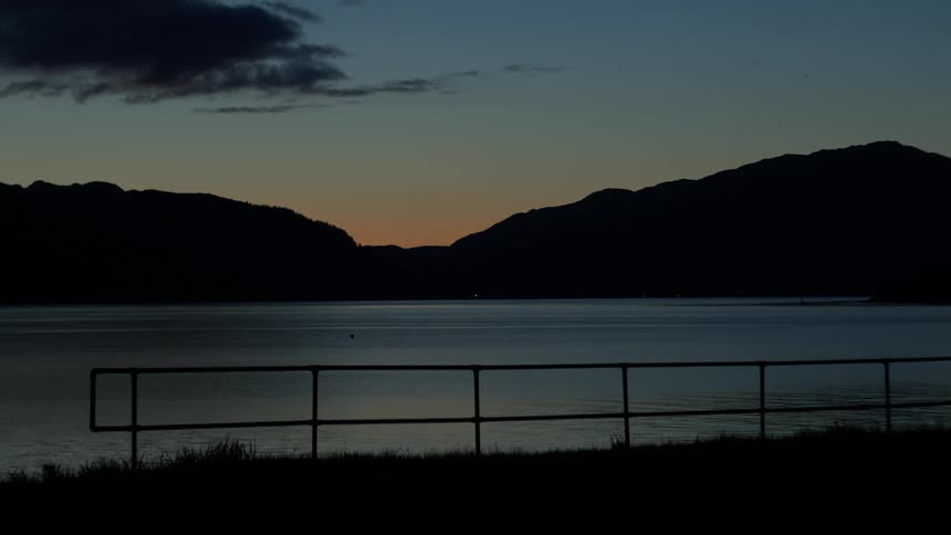 Sea landscape with silhouette of mountains in the background at dawn