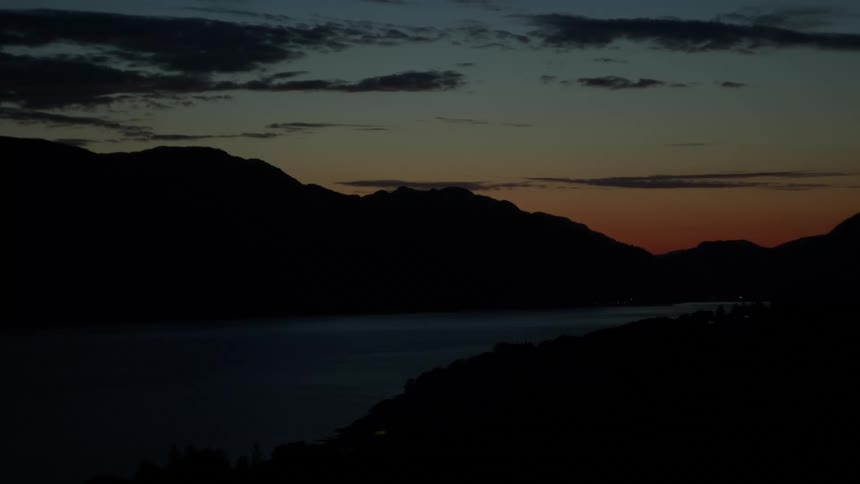A mountain view at night with a lake in the middle