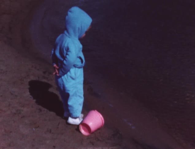 A child is walking around by the water