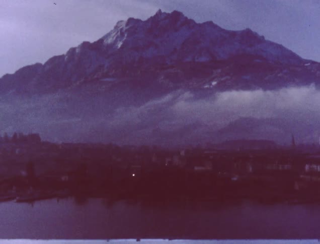 An older film of a mountain with a lake in front of it