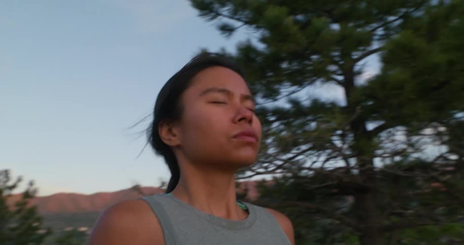 Woman with eyes closed while standing on a mountain