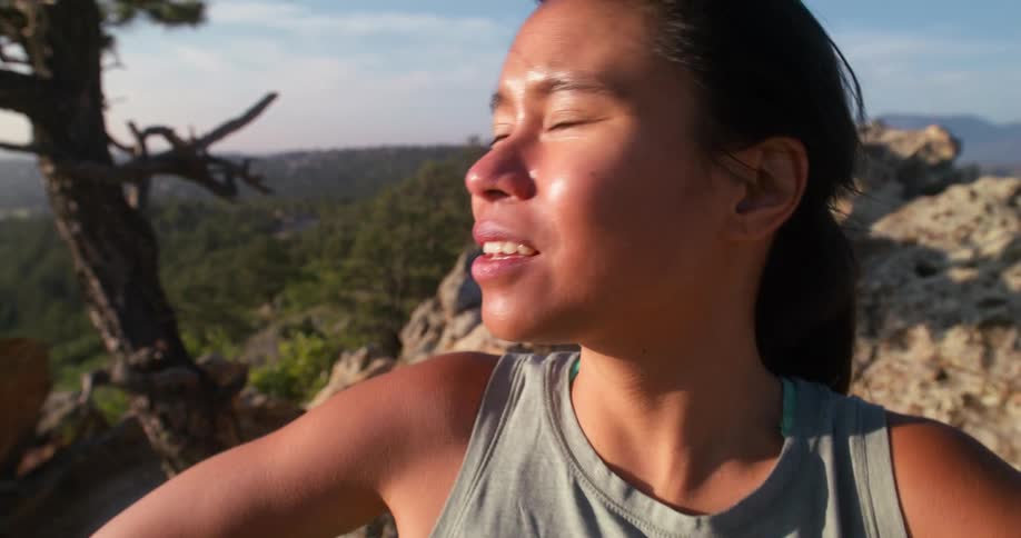 The woman is sweating and breathing heavily on the mountain