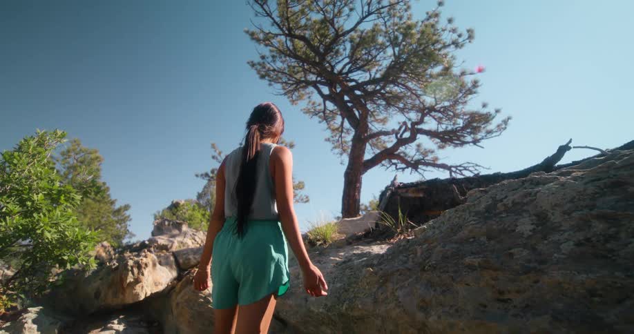 Woman standing on a trail through the mountains