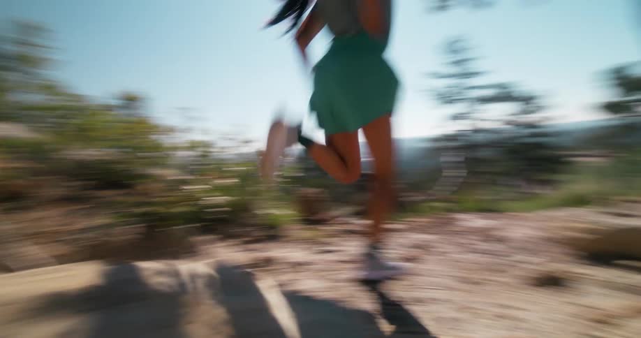 Woman running down a mountain trail