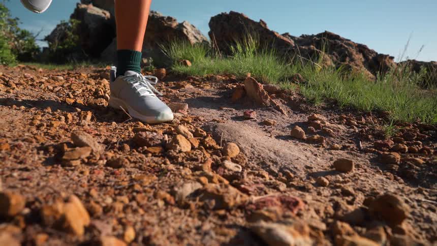 A person is running on a rugged earthy trail