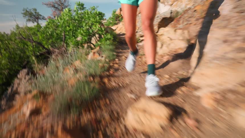 The woman is springing on the cliff of the mountain