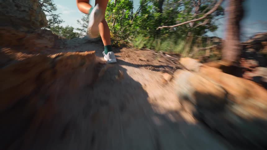 A woman runs down a steep mountain path in a zigzag pattern
