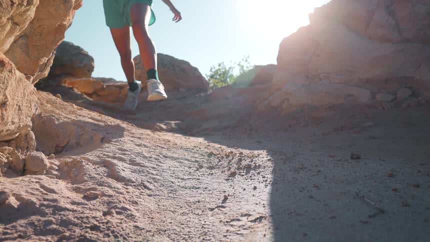 A female jogging down rocky terrain