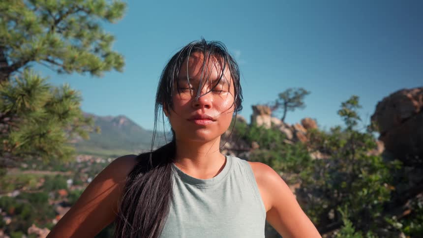 The woman is sweating on the mountain on a sunny day
