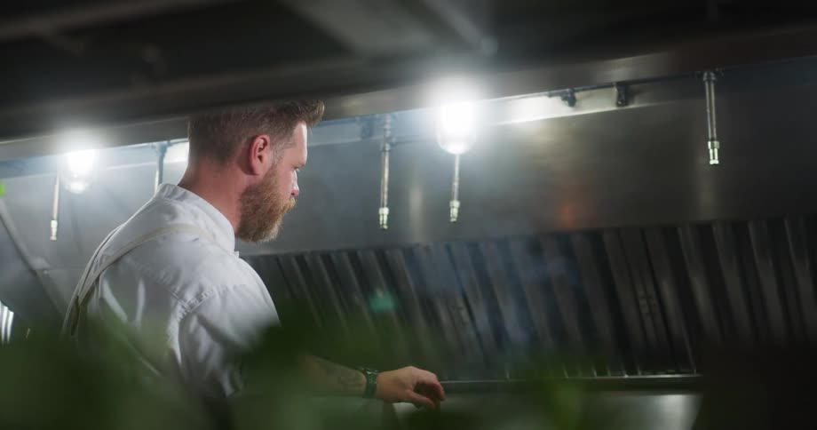 A chef grills a steak on a grill in the kitchen