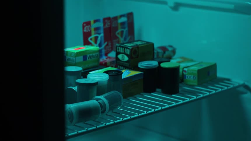 Picking up a film container from inside a refrigerator