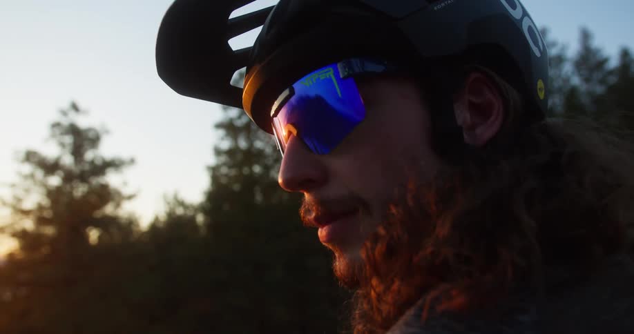 A man wears a bicycle helmet and sunglasses outdoors