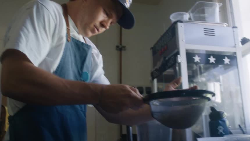 Man in apron sifting food