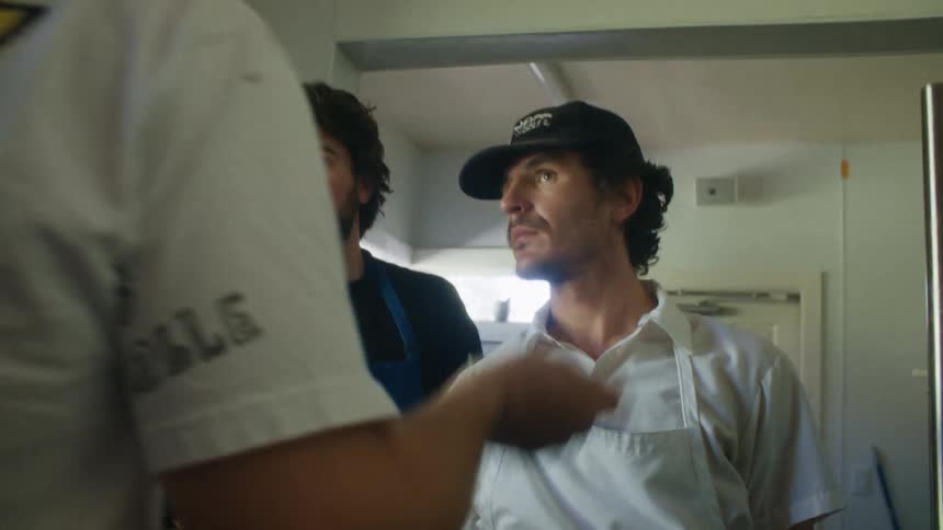 Male chefs in aprons talking in a restaurant kitchen