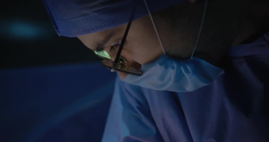 Two doctors perform surgery using surgical scissors in the theater