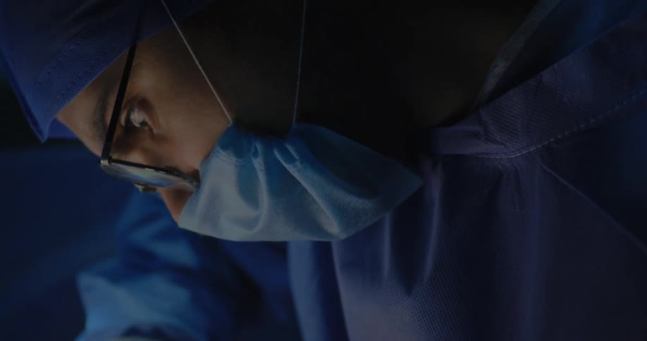 Side portrait of a concentrated surgeon wearing glasses