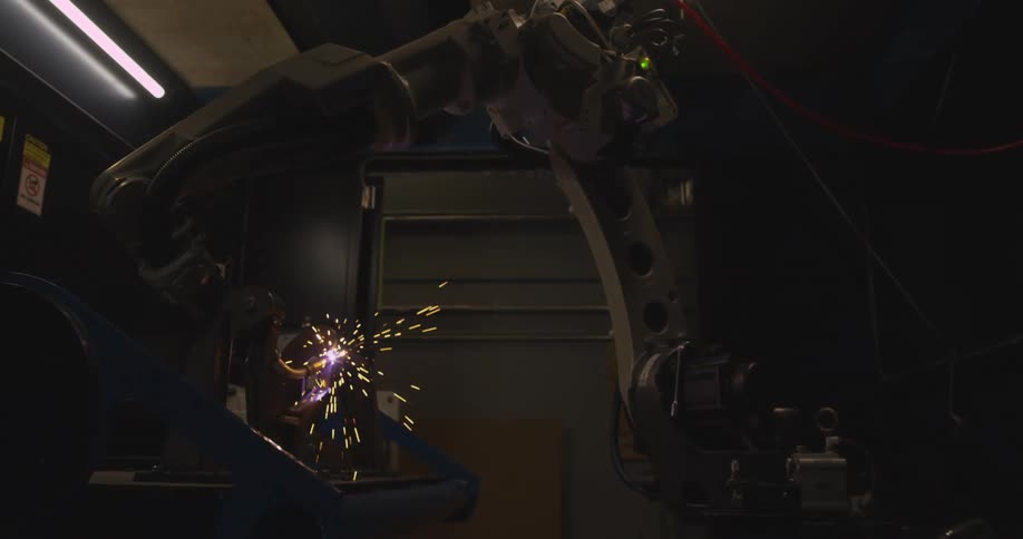 Mechanical and robotic arm welding an object