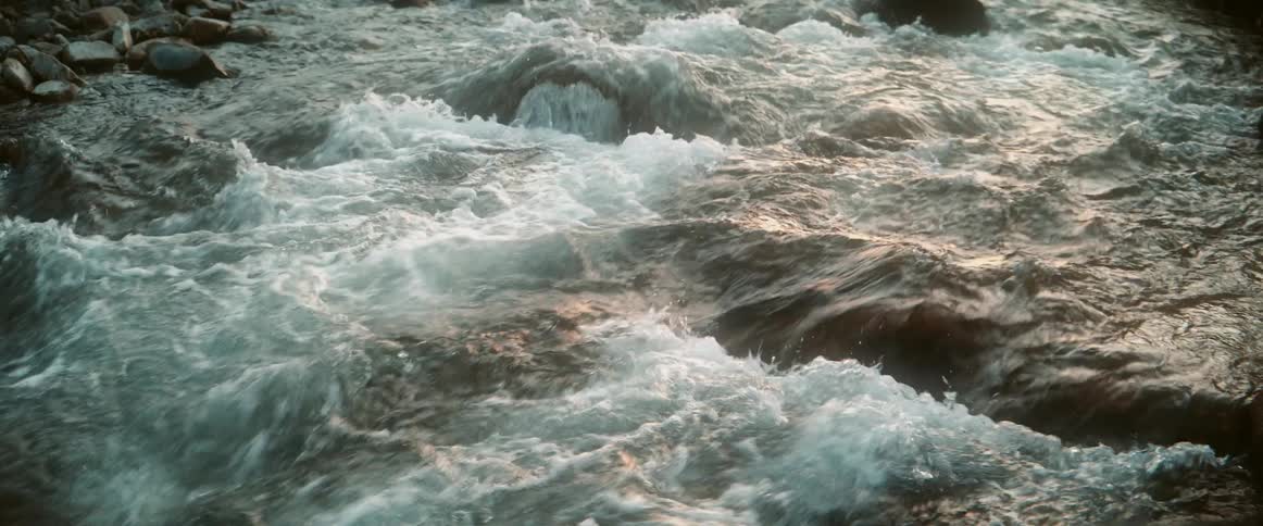 Water flows through a rocky stream at midday