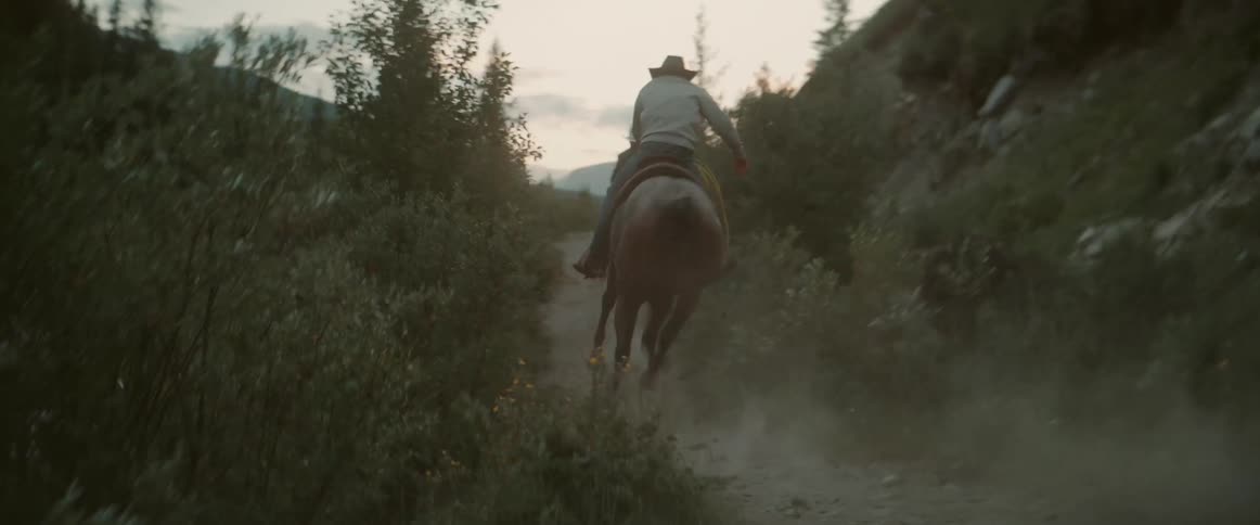 Two men on horseback on a mountain trail