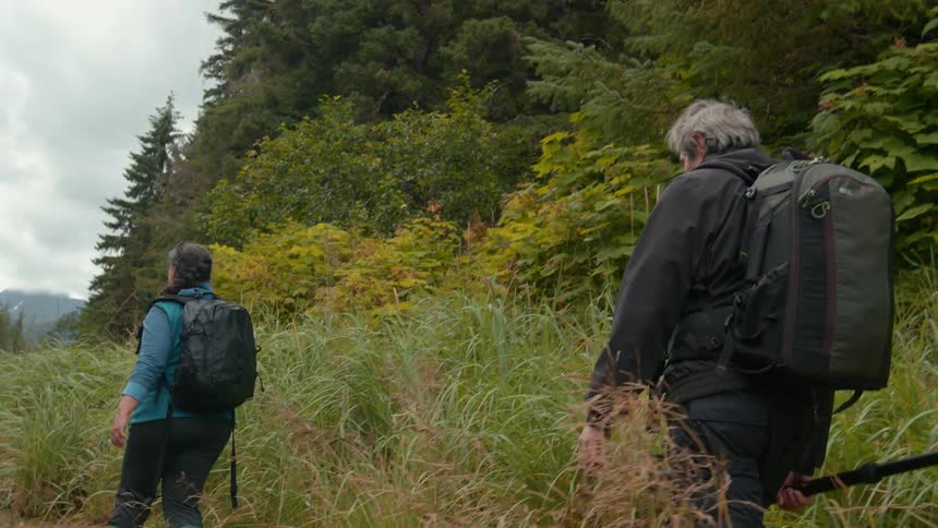 Elderly husband and wife are hiking outdoors together