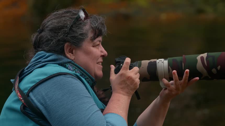 Photographer using a professional camera by a lake