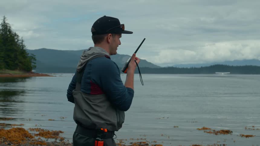 Man in cap at seaside using remote radio system