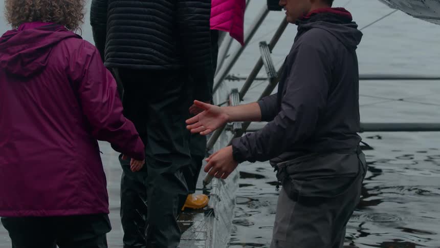 A man helps people get into the plane