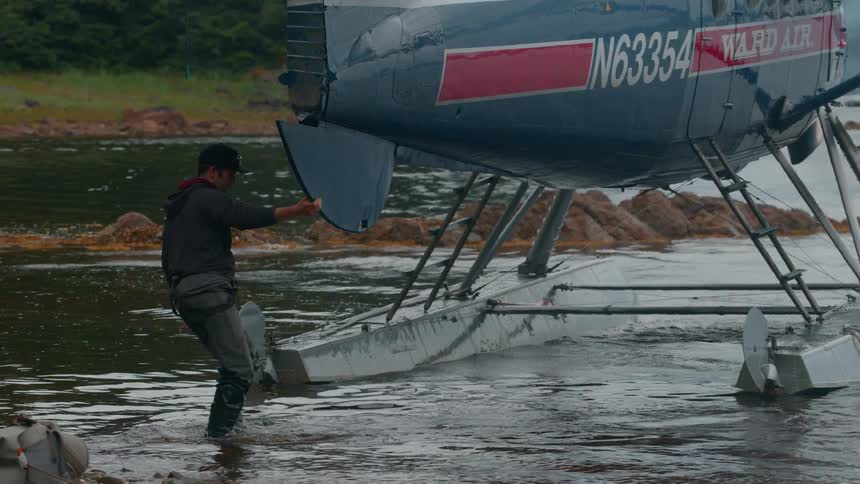 Man pulling a water plane into a lake