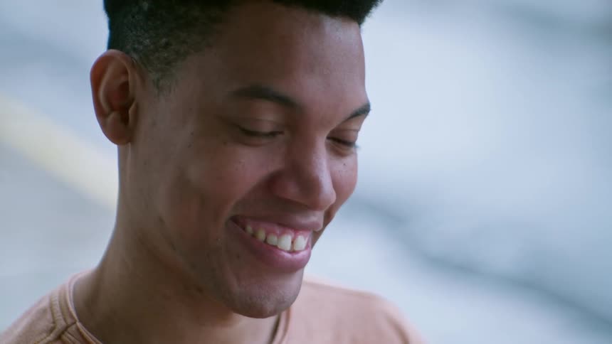 Young male is smiling and nodding his head while talking to someone