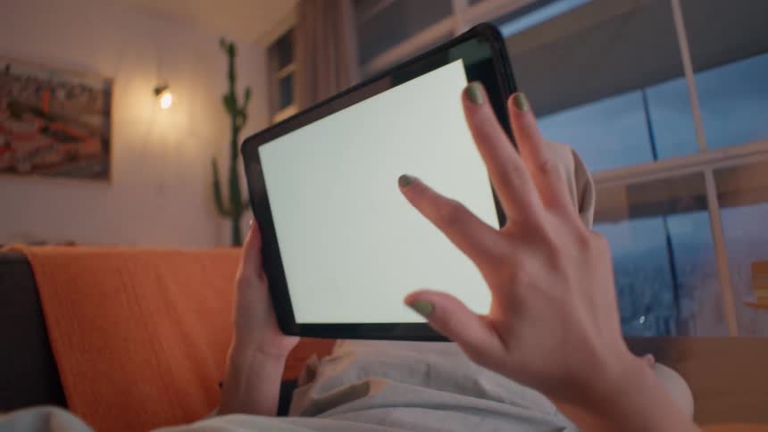 Person lying in living room and interacting with a tablet