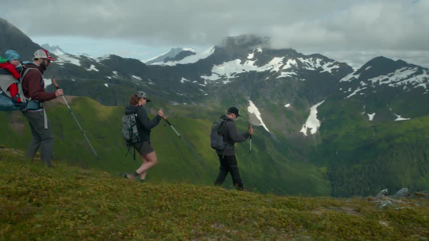 Group of people including a baby hiking up a mountain in winter