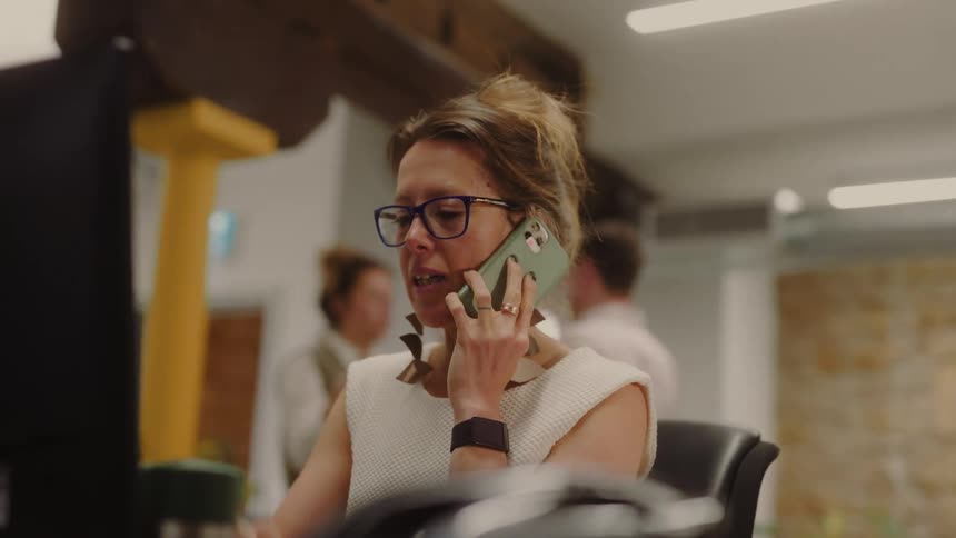 Woman in a work environment on a call on a smartphone
