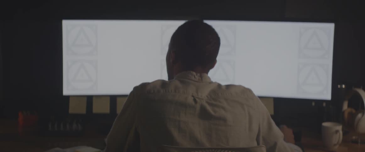 A man works at a computer with two monitors