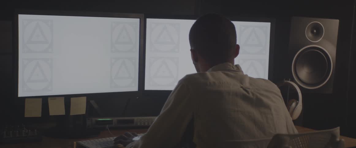 A man works at a computer with two monitors