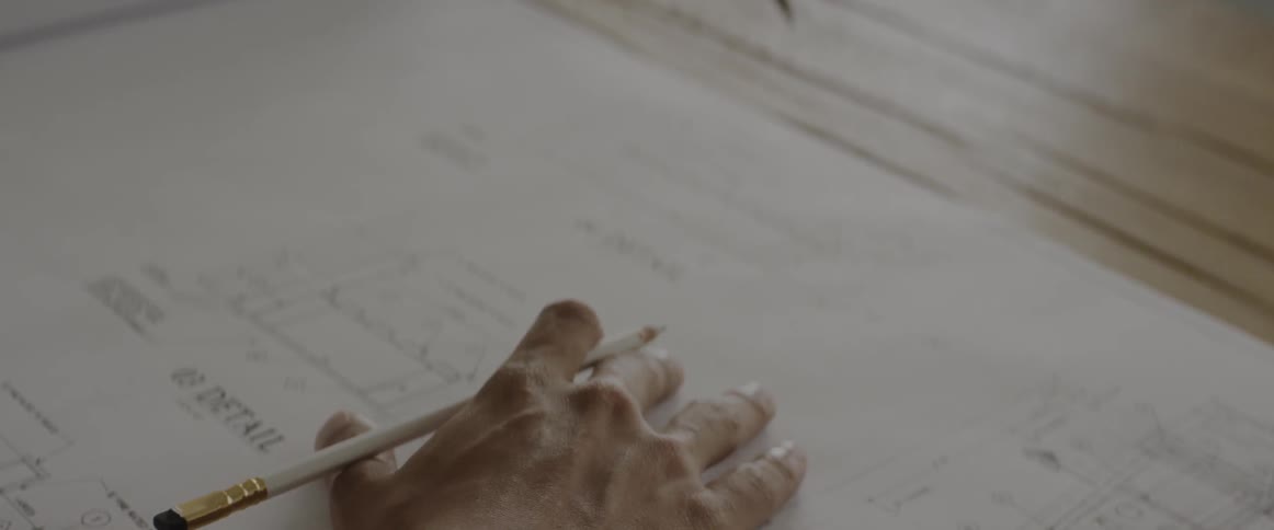 A person looks over paper documents with a pencil in hand