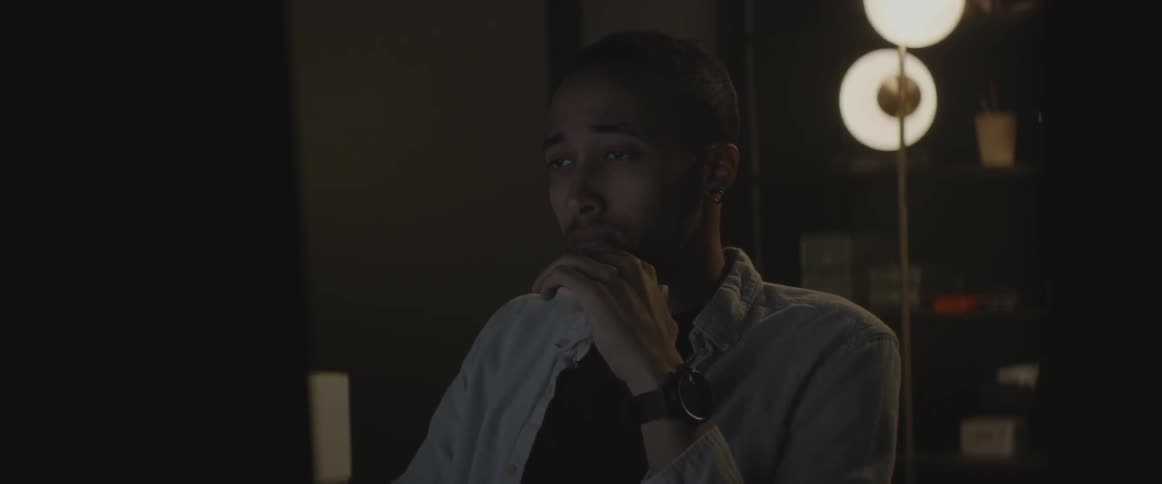 A man works at a computer in a dark room