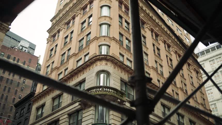 The scaffolding is across street from the tall buildings