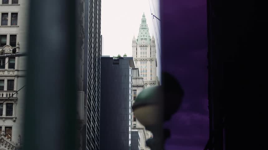A pointed skyscraper looms in the distance between two buildings