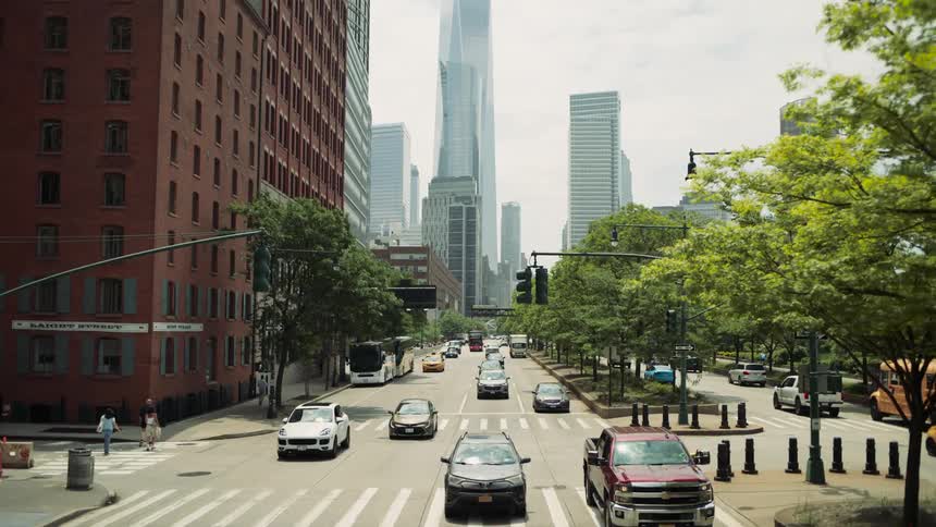 The cars drive down the center of the city