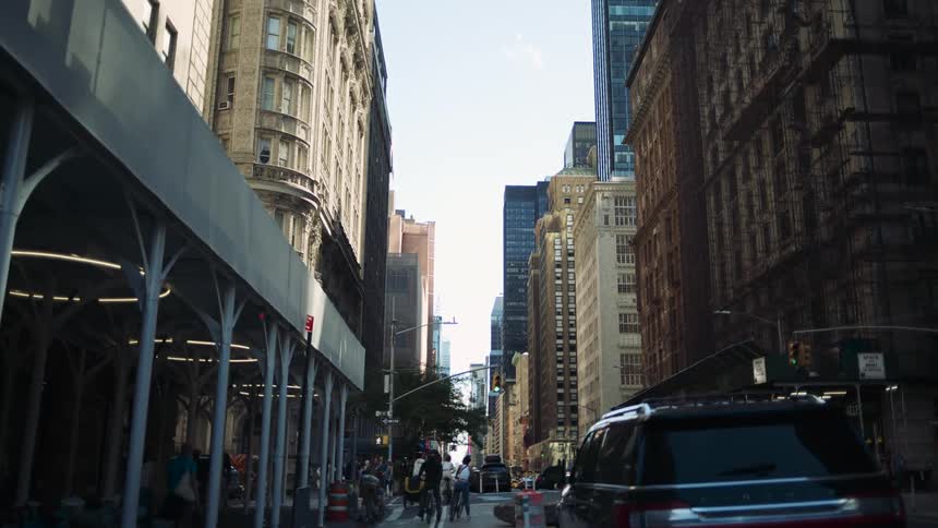 Busy street with cyclists cars and pedestrians surrounded by tall buildings in the city center