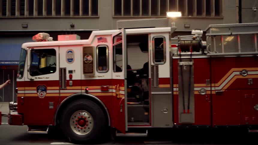 Group of firefighters with trucks on an urban road