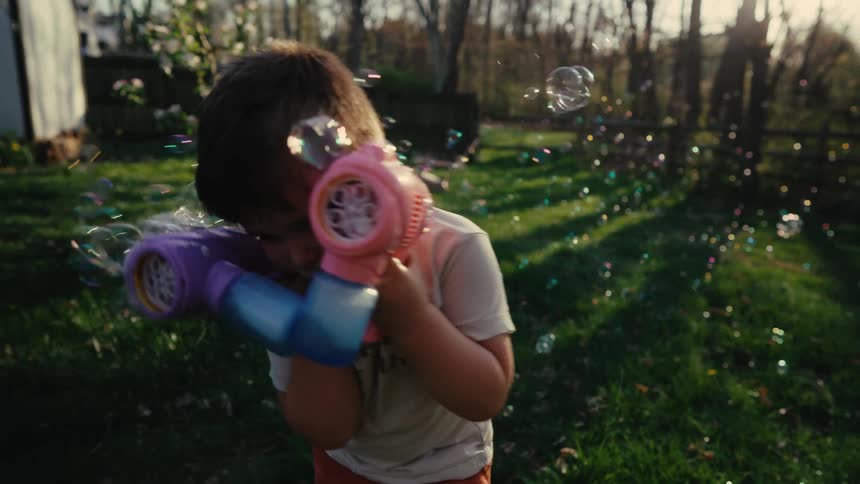 Boy playing with a soap bubble gun