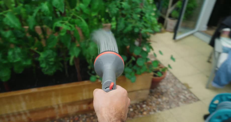 Time lapse point of view watering the garden with a spray nozzle