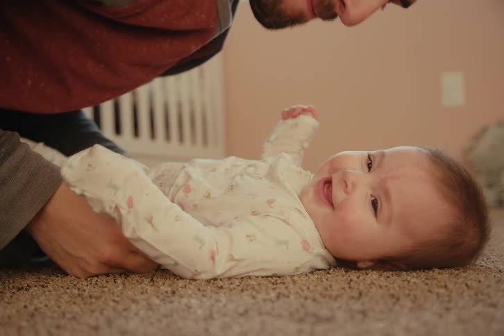 A father kisses his baby on the cheek